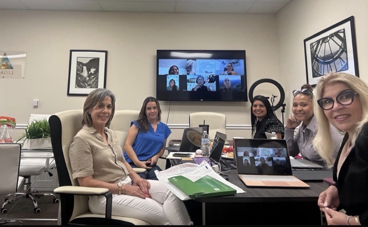 Equipo de Legacy en una reunión híbrida con colegas conectados por videollamada