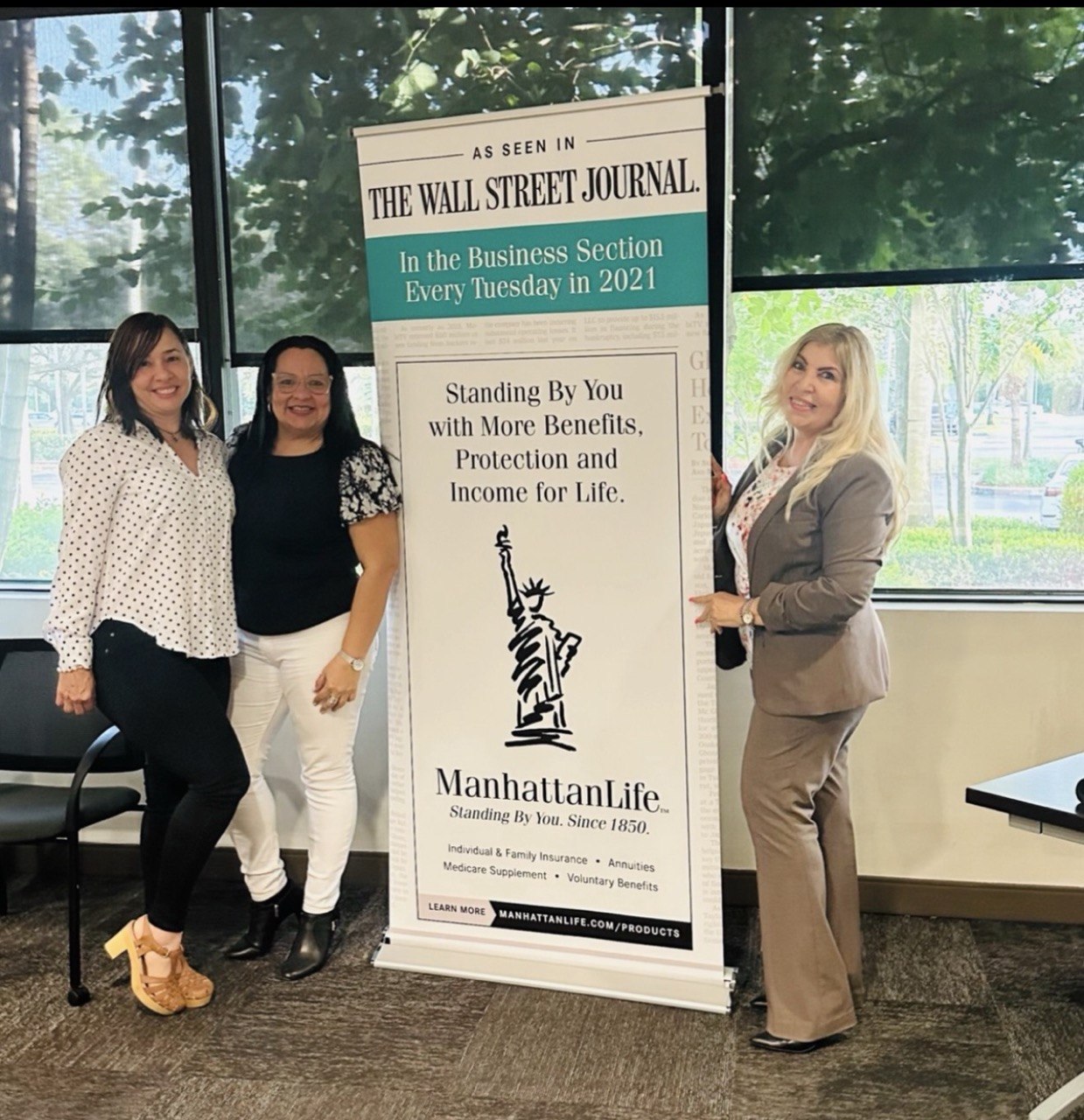 Asesoras de Legacy junto al banner de ManhattanLife en un evento de capacitación